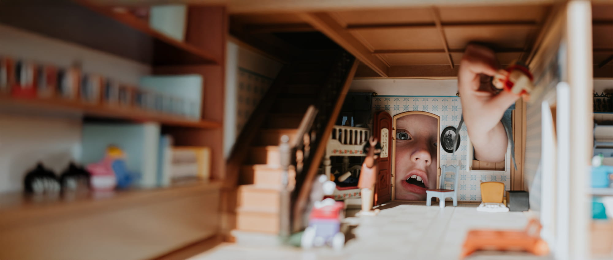Young child playing with a dolls house