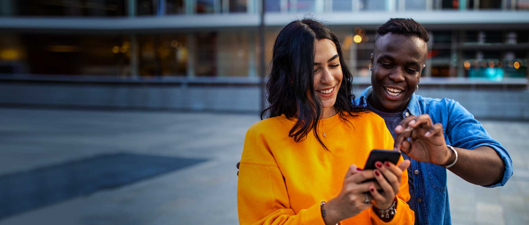couple of people looking at a mobile, joyfully