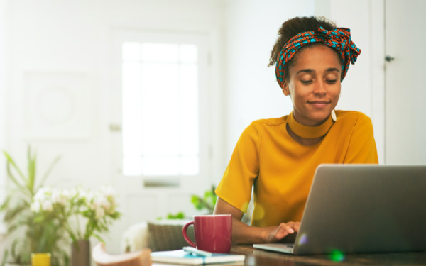 Woman in yellow top looking at laptop