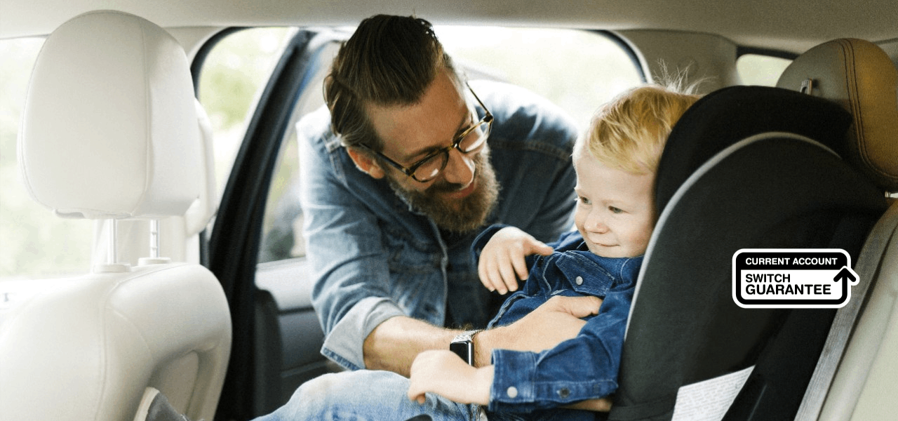 Man placing child in a car seat