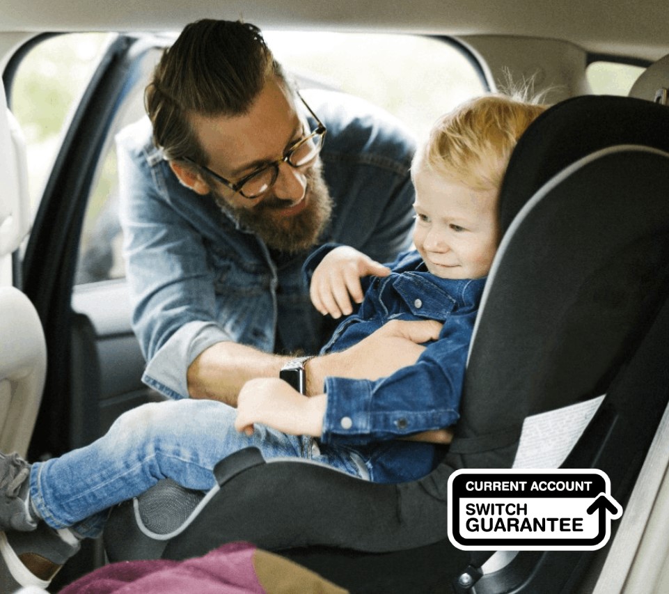 Man placing child in a car seat