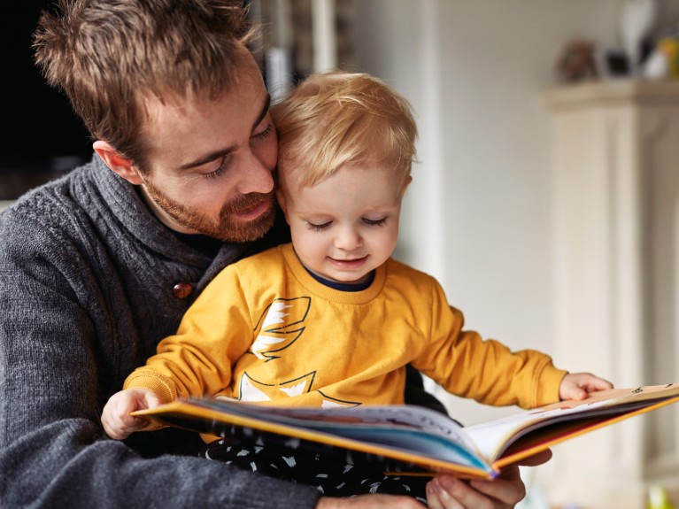 man with child reading