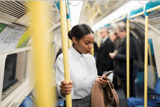 Women on the train looking at her phone.