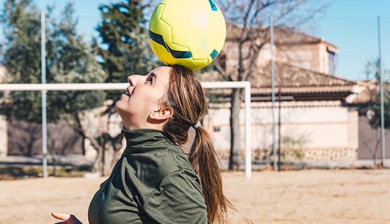 Woman balancing a football on her head
