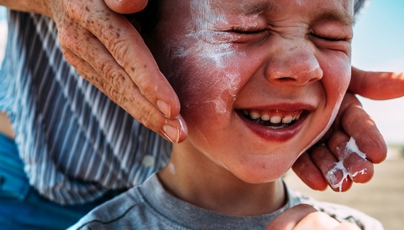 Sun cream being applied on a child's face.