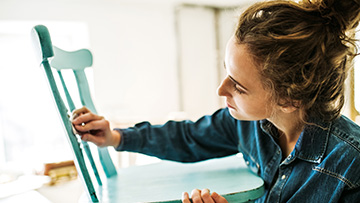 A woman painting a chair