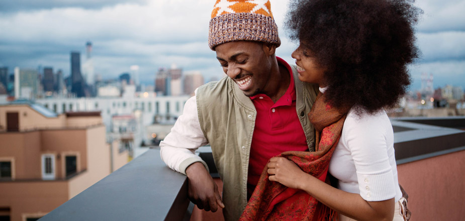 Couple laughing on rooftop.