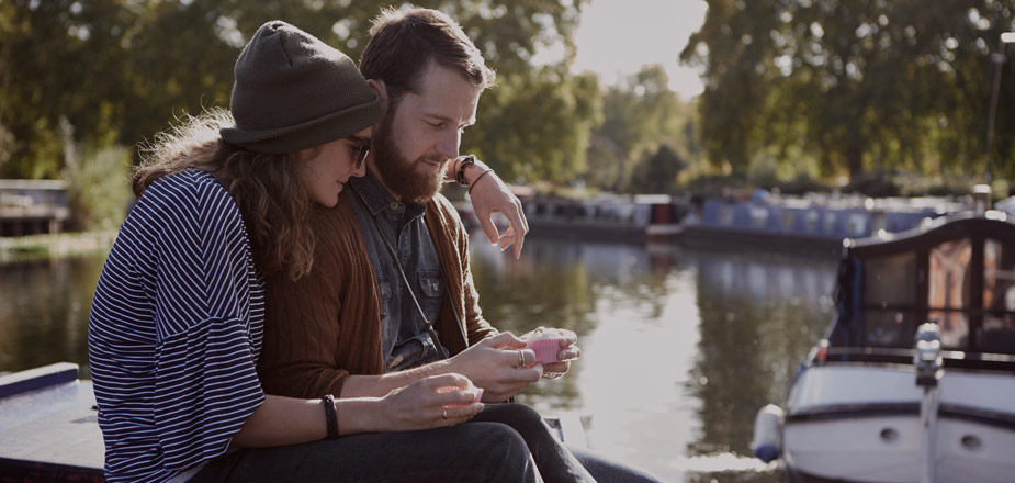 Couple sitting next to canal.