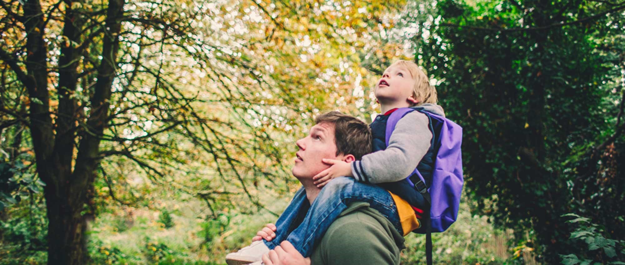 Man and child in forest.