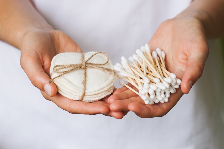 Cotton buds and pads in a pair of hands