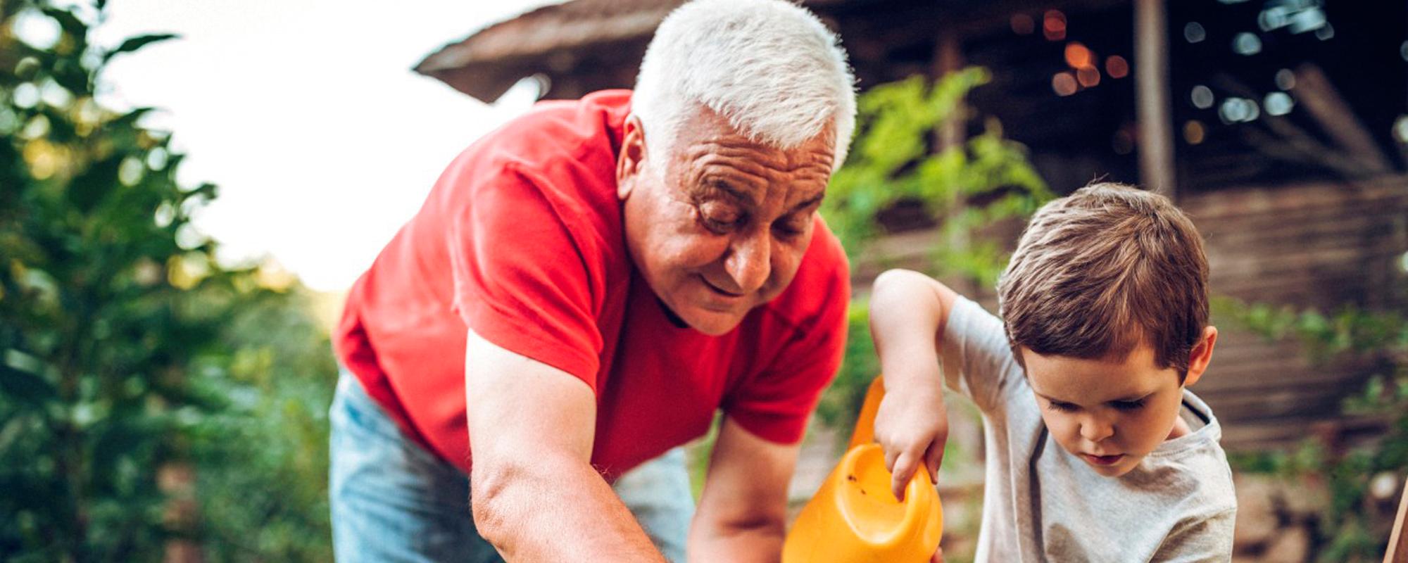 A young boy and his grandfather gardening.
