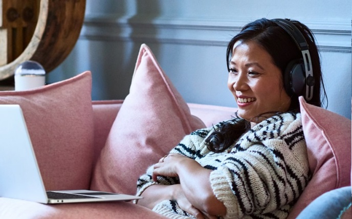 Woman with headphones on laptop